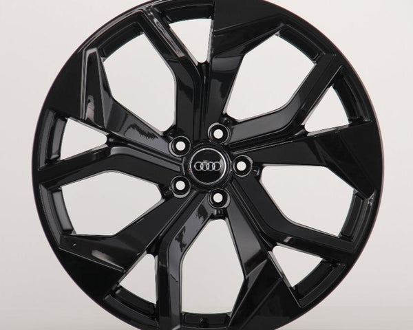 A glossy black car wheel with multiple spokes featuring the Audi logo at its center, displayed against a plain white background.