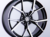 A black and silver alloy wheel with a distinctive star pattern and a 