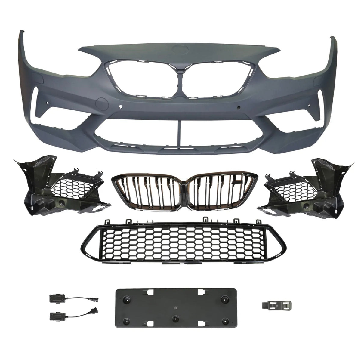 A collection of automotive parts includes a bumper cover, radiator grilles, and mounting brackets arranged on a plain background, suggesting components for vehicle front-end assembly.