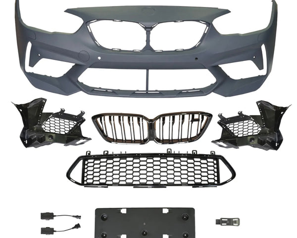 A collection of automotive parts includes a bumper cover, radiator grilles, and mounting brackets arranged on a plain background, suggesting components for vehicle front-end assembly.