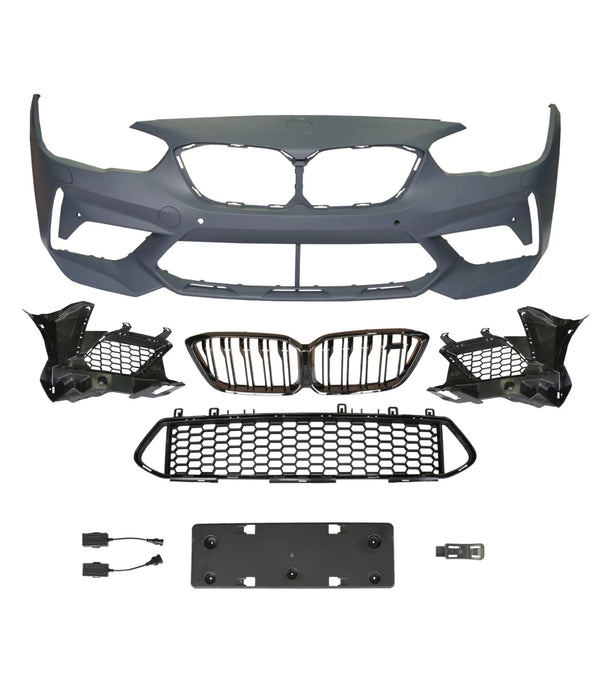 A collection of automotive parts includes a bumper cover, radiator grilles, and mounting brackets arranged on a plain background, suggesting components for vehicle front-end assembly.
