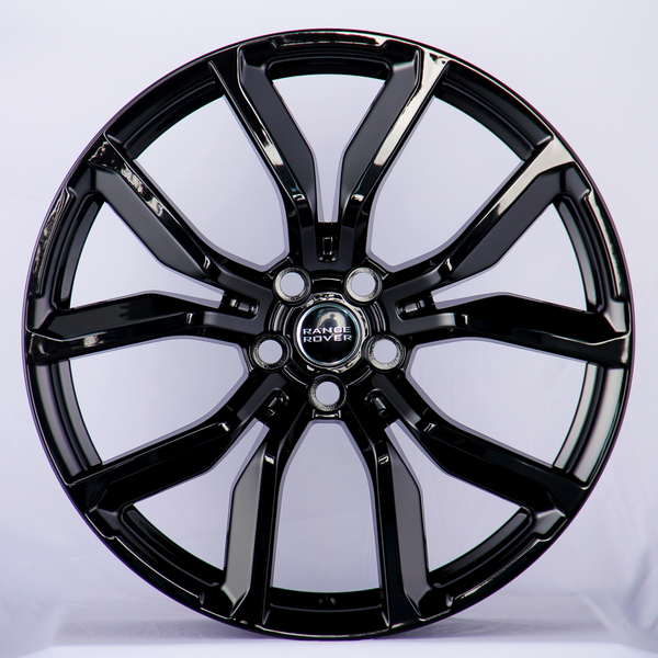 A shiny black alloy wheel features prominent spokes and a "Range Rover" logo at its center, set against a plain white background.