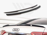 Two black car spoilers, one installed on the rear trunk of a white car with visible Audi logo, set in a well-lit parking environment.