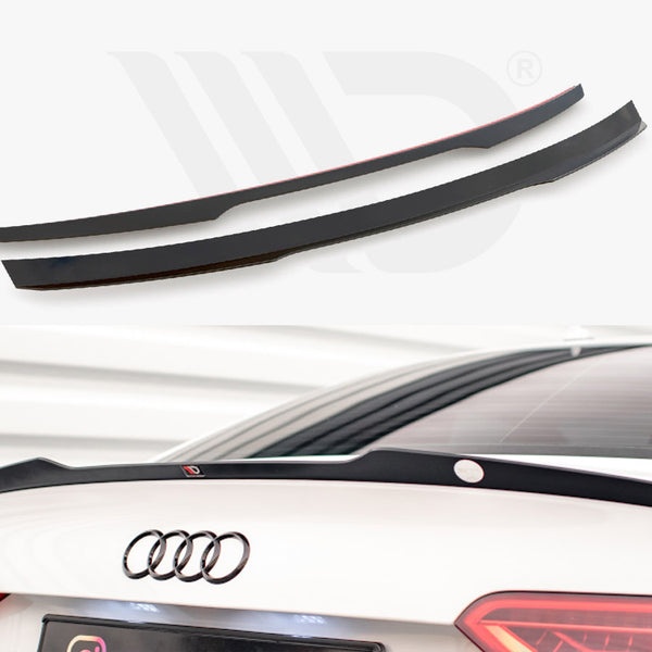 Two black car spoilers, one installed on the rear trunk of a white car with visible Audi logo, set in a well-lit parking environment.