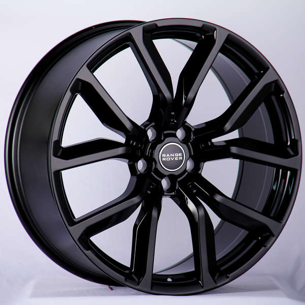 A glossy black alloy wheel featuring the "Range Rover" logo in the center, resting against a neutral background, highlighting its sleek design and intricate spoke pattern.