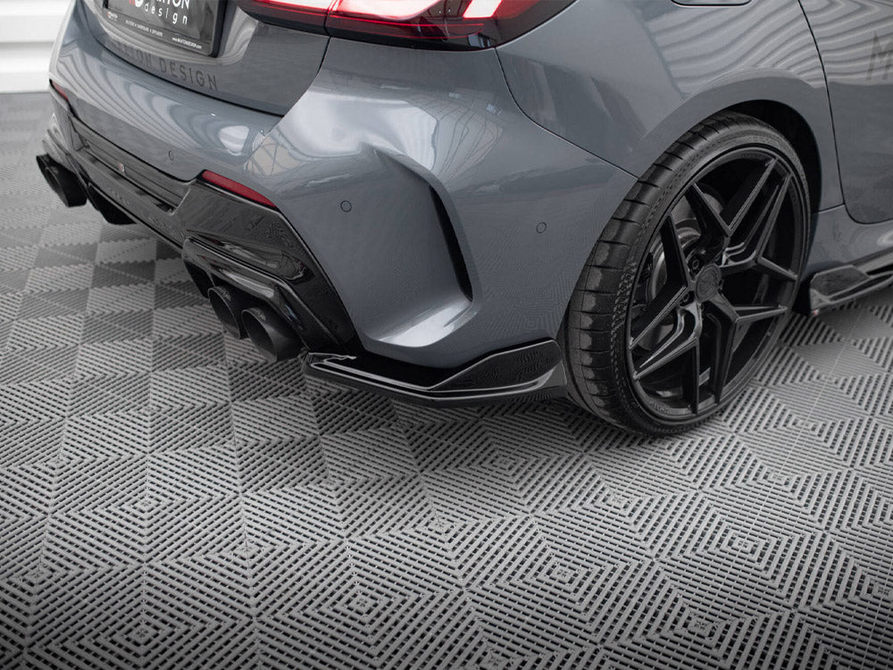 Gray car rear, showcasing a dual exhaust and black alloy wheel, parked on a patterned surface. Text on the license plate reads: "R1M DESIGN, wheels, safety-lip, carbonfiber, vanadiumwheels.com."