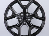 A glossy black car wheel rim features a five-spoke design with intricate detailing, set against a plain white background.