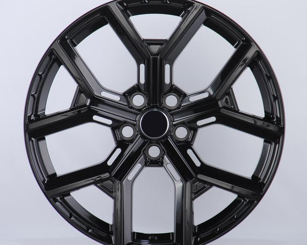 A glossy black car wheel rim features a five-spoke design with intricate detailing, set against a plain white background.