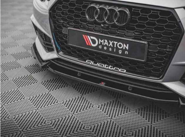 A car's front grille, featuring the Audi logo and honeycomb pattern, rests on a geometric-patterned floor. Text reads "MAXTON design" and "quattro" on the lower bumper.