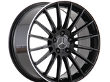 A black alloy wheel with a Mercedes logo, featuring multiple spokes, is shown against a plain white background.