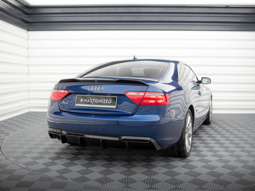 Blue Audi A5 parked in a garage with checkered flooring and white walls. The rear view shows a "#MAXTONIZED" license plate.