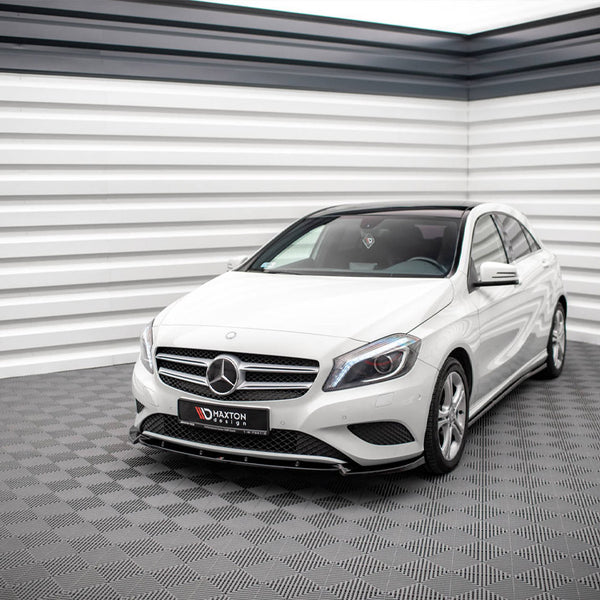 A white Mercedes-Benz car is parked in a modern, grey-tiled showroom with striped white and black walls. The front license plate reads "MAXTON design."