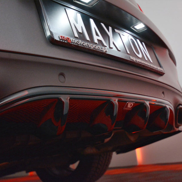 Rear of a car showing a customized diffuser with red accents; a license plate reading "MAXTON" is illuminated. Surrounding environment has a dim, red-lit ambiance.