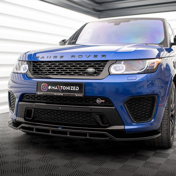 A blue Range Rover is parked indoors on a patterned floor. The license plate displays "#MAXTONIZED," and the environment features white and gray paneling on the walls.