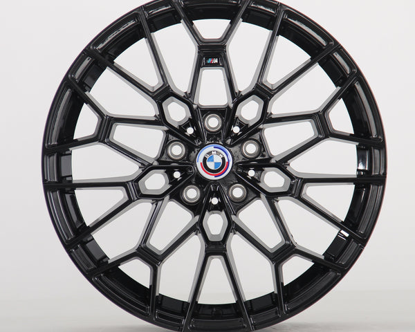 A glossy black, intricately designed car wheel with a central BMW logo and "M" insignia, set against a plain white background.