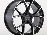 A glossy black alloy wheel with a five-spoke pattern, featuring the Audi logo at the center, displayed against a plain white background.
