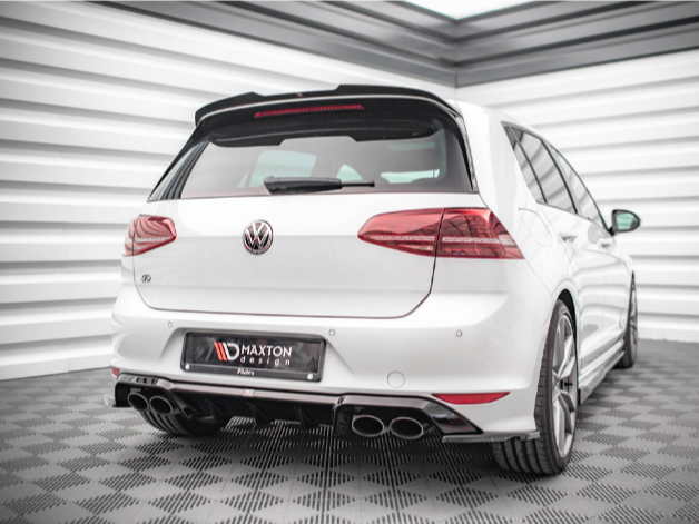 A white Volkswagen hatchback is parked in a modern showroom with checkered flooring and white paneled walls. The license plate reads "MAXTON DESIGN."