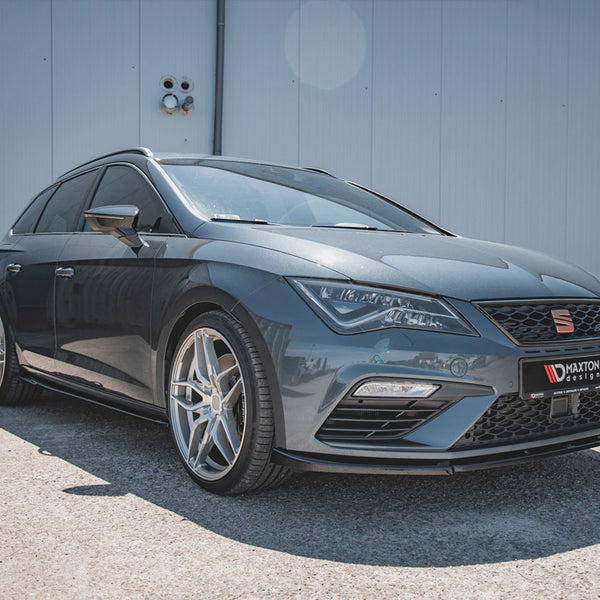 Car parked on a concrete surface, featuring sporty alloy wheels and sleek design. The background is a plain, light-colored building wall. License plate reads "MAXTON design."