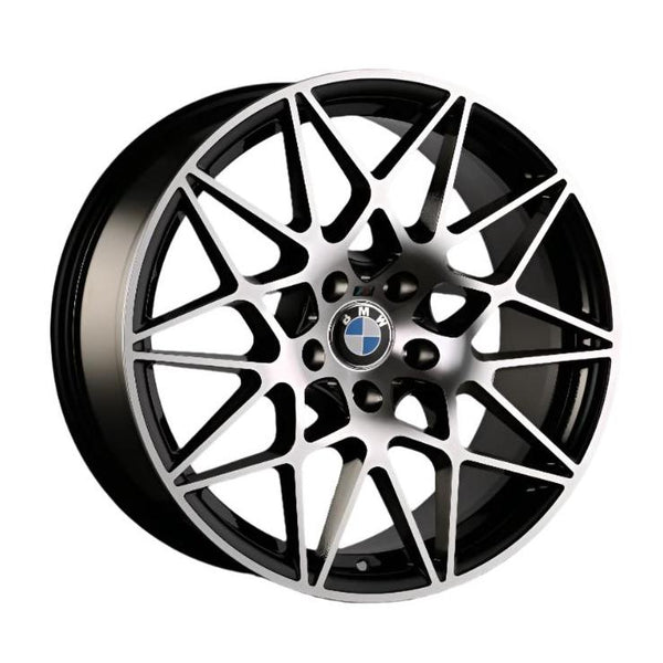 A multi-spoke alloy wheel with geometric patterns features the BMW logo at the center. It has a metallic finish and is designed for automotive use.