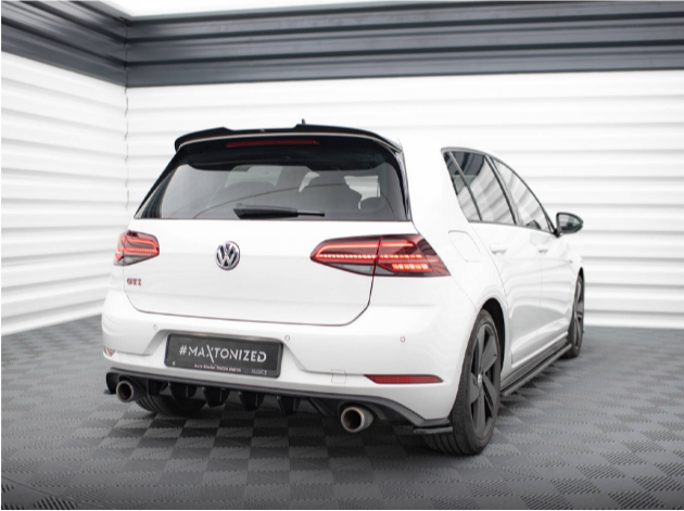 A white Volkswagen GTI is parked on a checkered floor in a bright, industrial-style room. The car has dual exhausts and black wheels. Text: "#MAXTONIZED" on the license plate area.