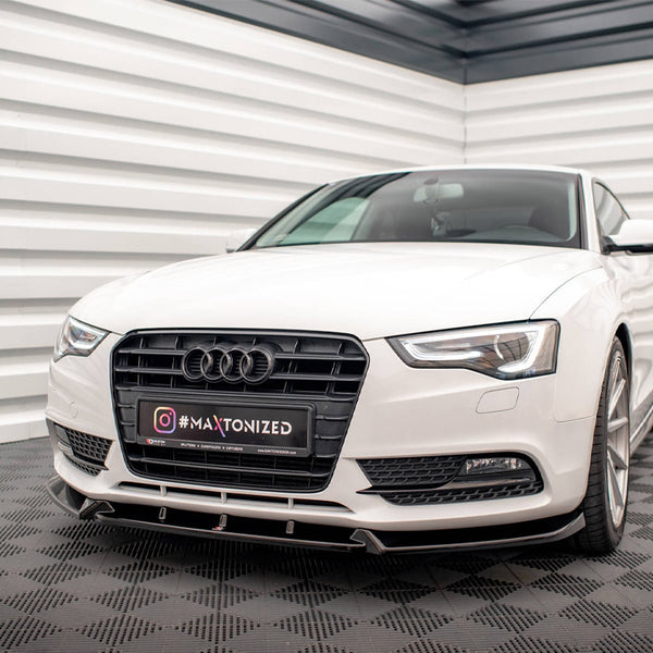 A white car is parked, featuring a prominent grille with a logo, in a modern, striped white and gray room. The license plate reads "Instagram #MAXTONIZED."