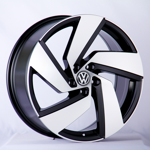 A car wheel rim with a sleek black and white design, featuring the Volkswagen logo in the center, displayed against a plain white background.