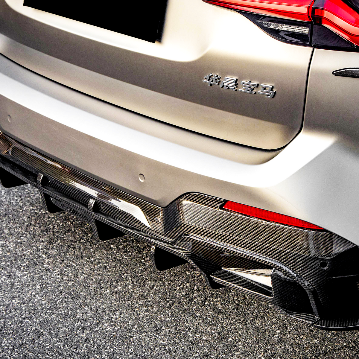Car rear with a carbon fiber diffuser, parked on asphalt. "华晨宝马" text on the back, red taillights illuminated, set in bright daylight.