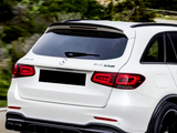 A white SUV drives on a road with surrounding greenery. Text on the vehicle reads 