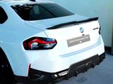 A white BMW car, rear view, features a spoiler and darkened taillights. 