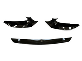 Three glossy black car body parts are displayed against a white background, featuring two angular side components and a straight centerpiece below, resembling a front splitter set.