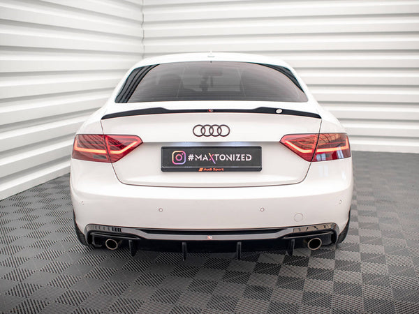 White car parked in a grid-patterned room, highlighted by the rear view with red taillights and dual exhausts. License plate reads "#MAXTONIZED Audi Sport" with an Instagram logo.