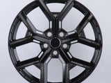 Black, glossy, multi-spoke alloy wheel; resting upright in a well-lit studio setting; casting a slight shadow on the white background.