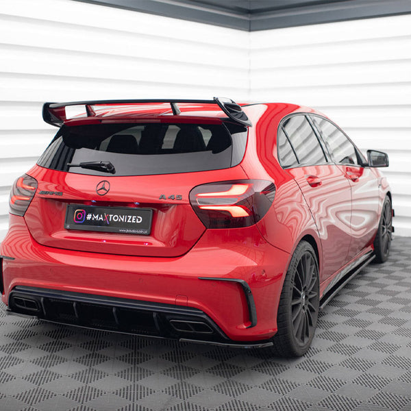 A red Mercedes A 45 AMG is stationary in a modern, brightly lit room with checkered flooring and striped walls. License plate reads "#MAXTONIZED www.maxtondesign.eu".
