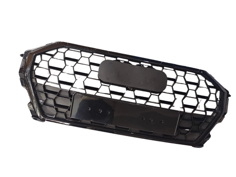 A black honeycomb car grille with an octagonal shape, featuring two rectangular mounting plates, lies against a plain white background.