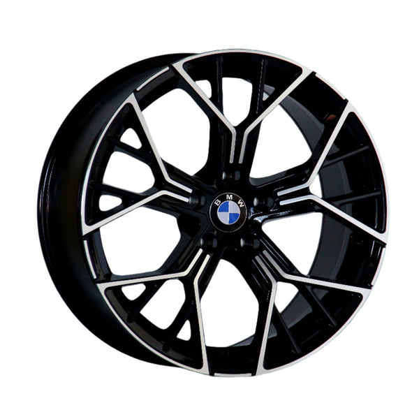 A black and silver alloy wheel with a geometric design features the BMW logo in the center, positioned against a plain white background.