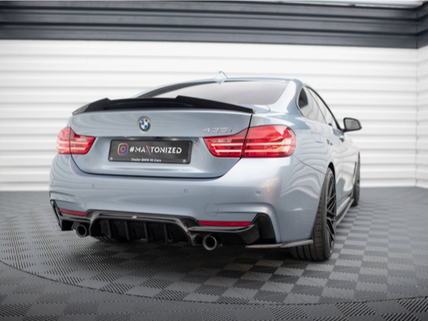 A silver BMW 435i is parked in a showroom with checkered flooring and white walls. The license plate reads "@MAXTONIZED Dealer BMW M Cars."