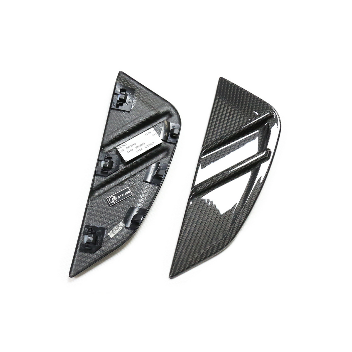 Two carbon fiber car trim pieces lie on a plain surface; one shows a glossy, ribbed exterior, while the other reveals a textured interior with mounting clips and labels.