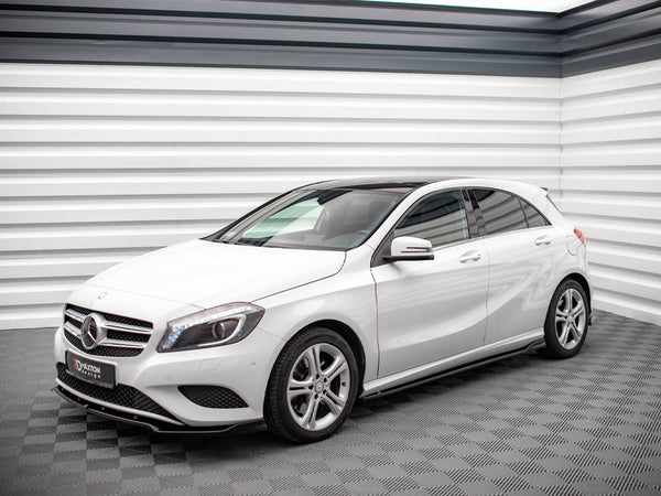 A white Mercedes-Benz hatchback is parked in a modern showroom with sleek, textured walls. A sign on the front reads "D'AXTON DESIGN."