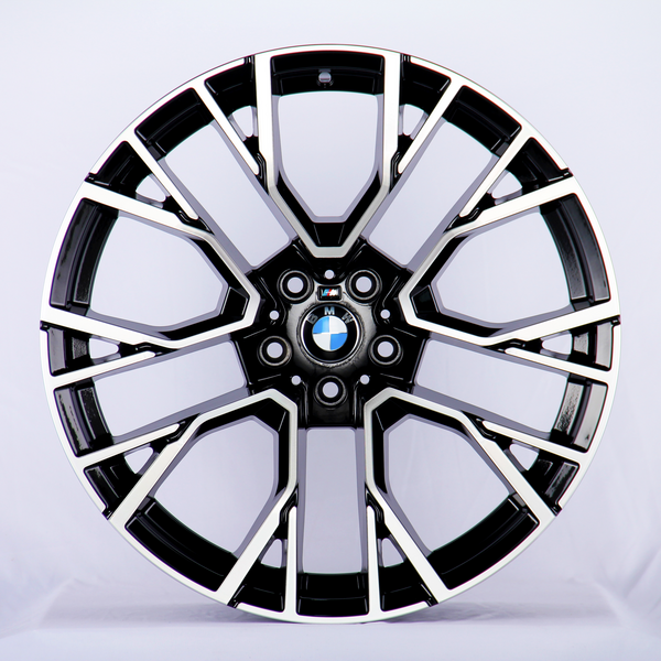 The object is a car wheel rim with a sleek, multi-spoke, black-and-silver design, displaying a BMW emblem in the center. The context is a plain, white background.