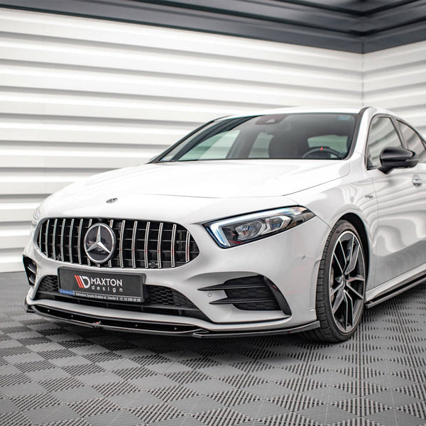A white Mercedes car is parked on a checkered floor in a modern, sleek room with white paneled walls. The license plate reads "MAXTON design."