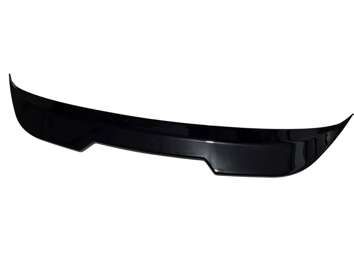 A glossy black car spoiler, segmented with slight curves, rests isolated on a plain white background.