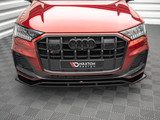 A red Audi with a black front grille is stationary on a patterned floor. 