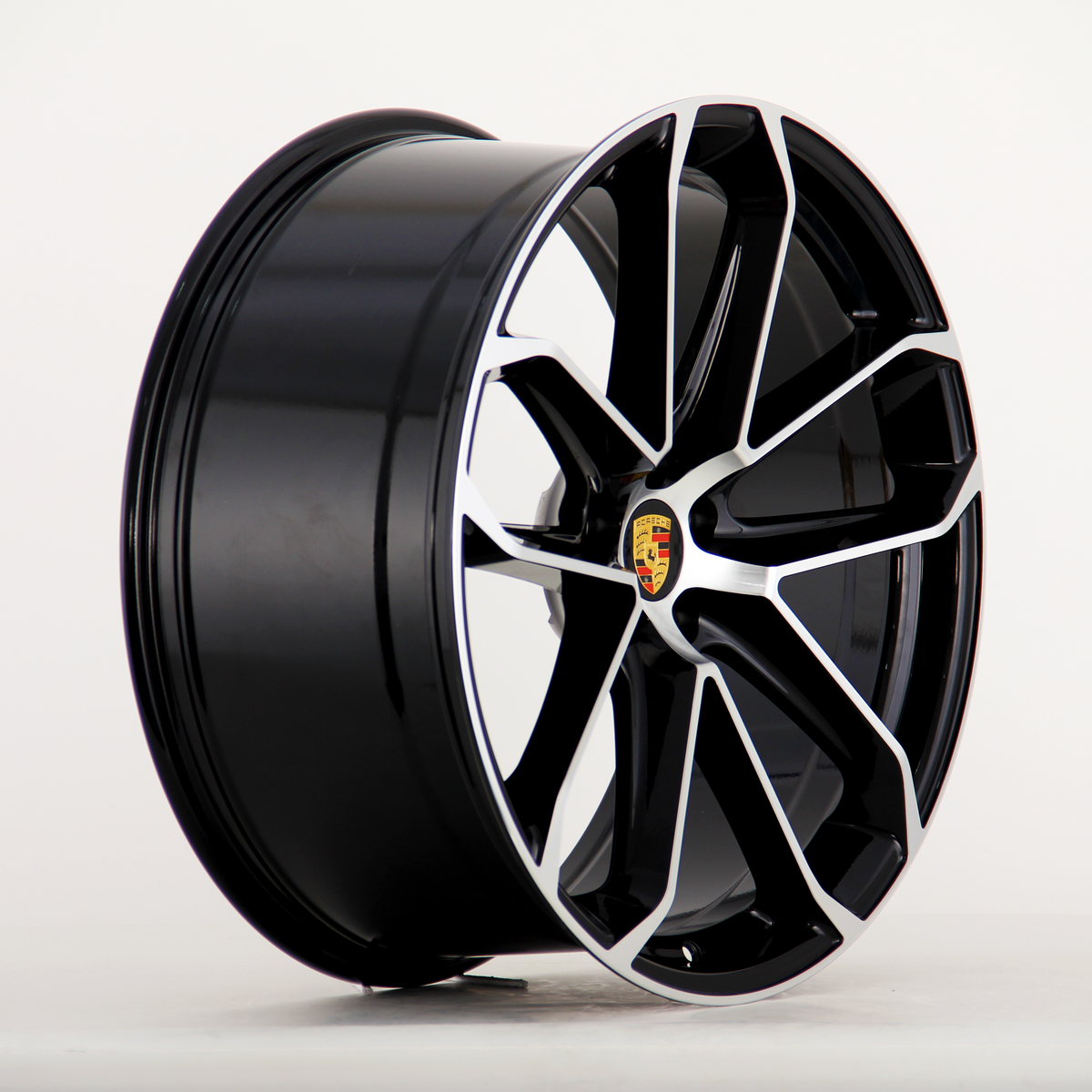 A sleek black alloy wheel with a silver trim and an emblem at the center, displayed in profile against a plain white background.