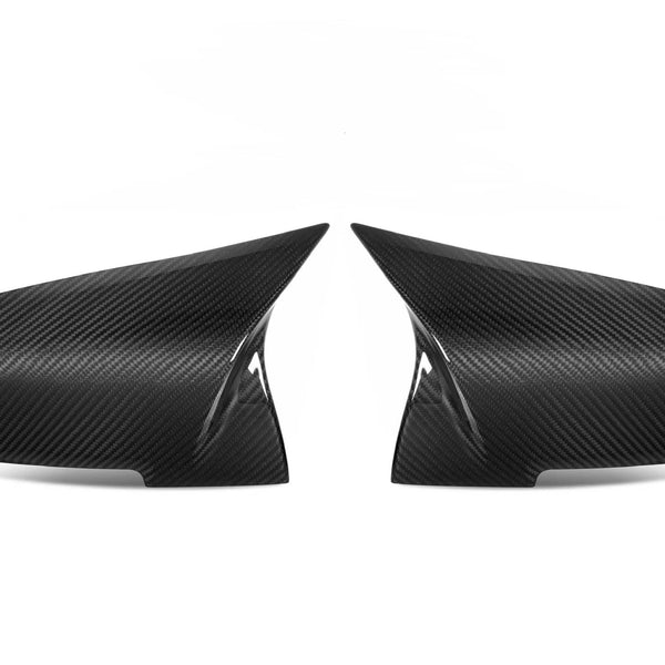 Two carbon fiber side mirror covers face each other on a plain, white background, showcasing their sleek, aerodynamic design.