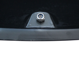 A metal bolt is fixed onto a flat black and gray surface, surrounded by dark background.