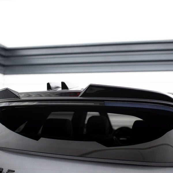 A silver car with a sleek roof spoiler is parked in a clean, modern garage. Text on the back reads "RANGE."
