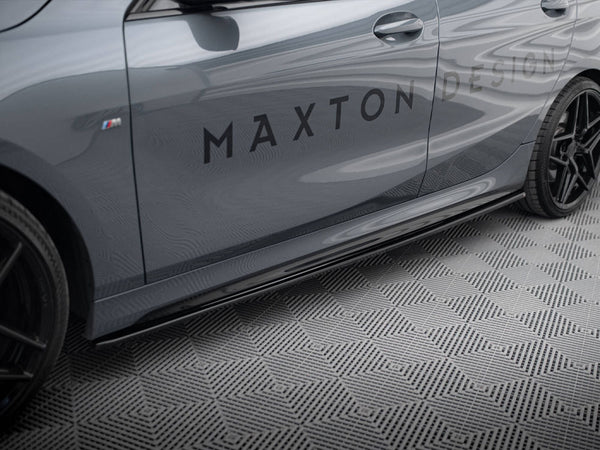 A sleek grey car, stationary, displays the text "MAXTON DESIGN" on its side, set on a textured geometric-pattern floor. Black wheels and sporty styling enhance its modern appearance.