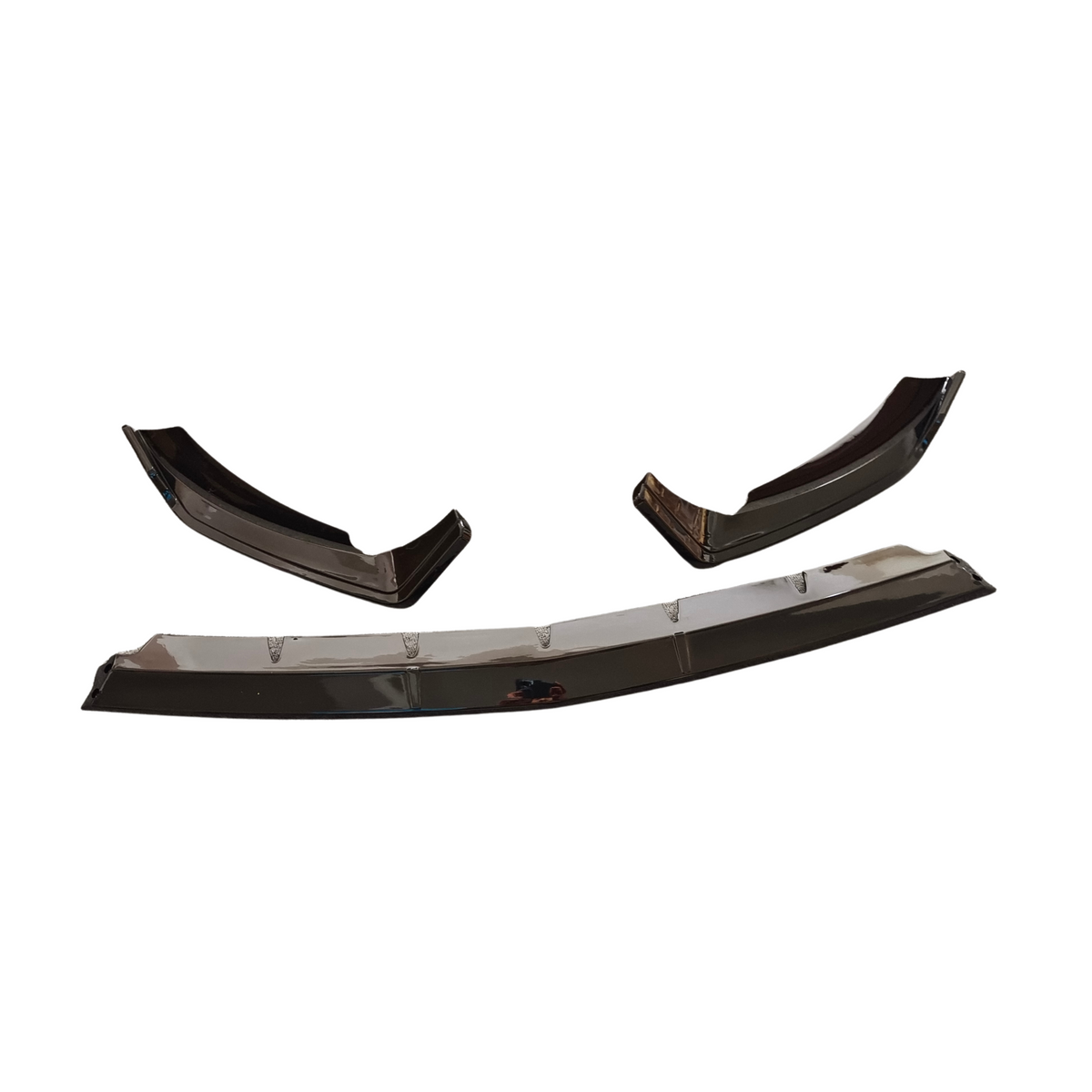 Three glossy black plastic car bumper splitters are laid out against a plain white background. The largest piece is rectangular with angled edges, and two smaller are curved.