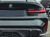 The rear view of a black BMW car with a visible logo, quad exhausts, a 