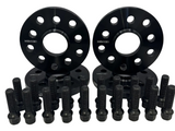 Two black wheel spacers with bolt patterns, surrounded by several black wheel bolts, are arranged on a white background. Text on spacers reads 